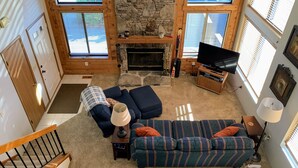 Ein gemütliches Wohnzimmer mit Kamin, Fernseher und einer Couch.