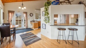 A modern kitchen with a central island, wooden flooring, and a hanging plant. - Saddle Ridge Retreat (Gardiner)