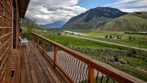 A wooden deck with a view of a mountainous landscape. - Saddle Ridge Retreat (Gardiner)