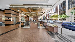 A modern lobby with a central staircase, escalators, and a 'Lobby' sign. - Chic Dt Honolulu Executive Condo 1 Bedroom Condo (Honolulu)