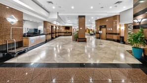 A spacious lobby with a reception desk, a seating area, and a plant. - Chic Dt Honolulu Executive Condo 1 Bedroom Condo (Honolulu)