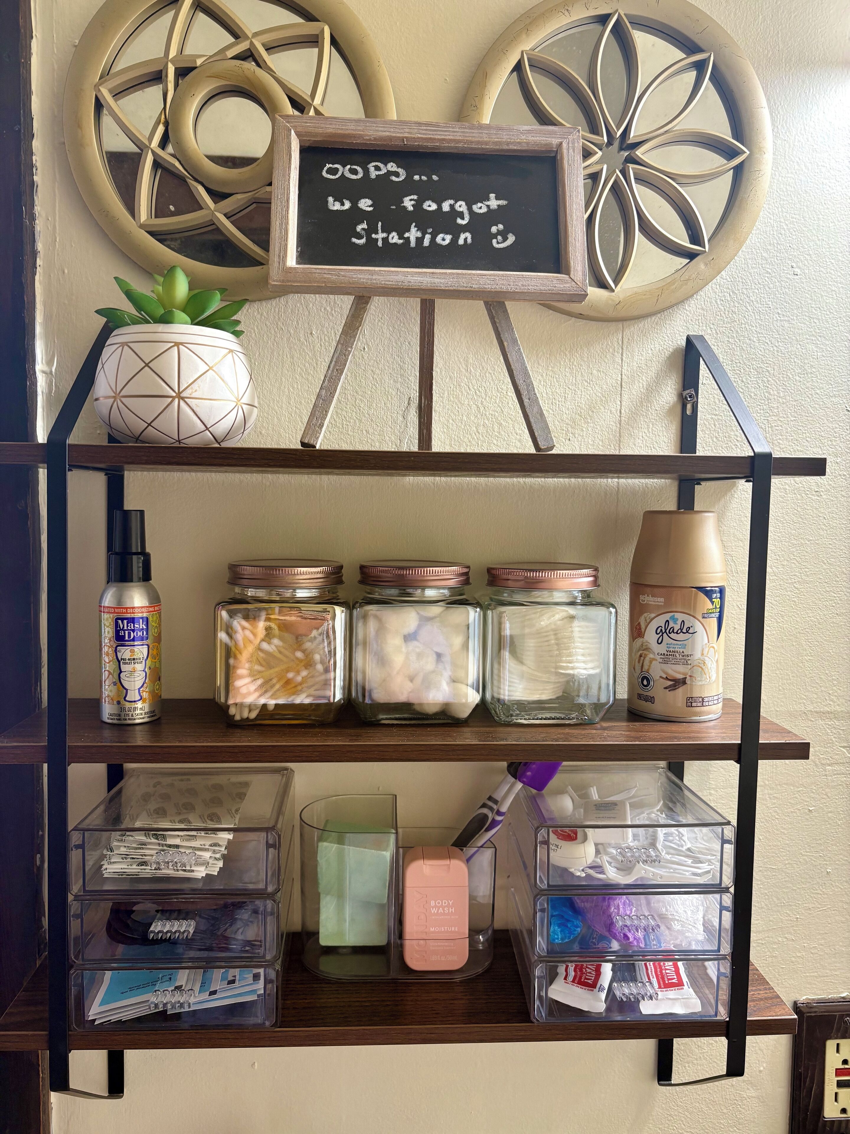 A shelf with various items including a chalkboard sign, jars, and storage boxes.