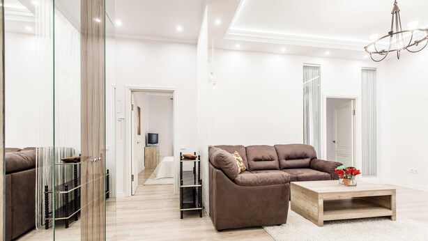 A modern living room with a brown sofa, a wooden coffee table, and a glass partition. - Minsk Apartment Lux on Nezavisimosti 43 (Minsk)