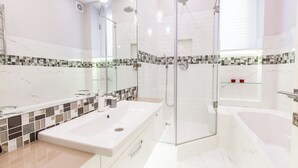 A modern bathroom with a glass-enclosed shower, a large bathtub, and a vanity with a sink. - Minsk Apartment Lux on Nezavisimosti 43 (Minsk)