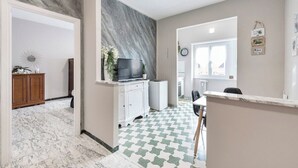 Un salon moderne doté d’un sol en marbre, d’un téléviseur à écran plat et d’un coin repas avec un sol à carreaux.