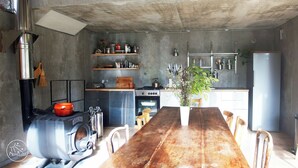A kitchen with a wooden table, a stove, and a refrigerator. - Self-catering ecogîte in the heart of the forest at La Chapelle-en-Vercors (La Chapelle-en-Vercors)