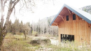 A wooden cabin with a sloped roof, situated in a forested area with a mountain backdrop. - Self-catering ecogîte in the heart of the forest at La Chapelle-en-Vercors (La Chapelle-en-Vercors)