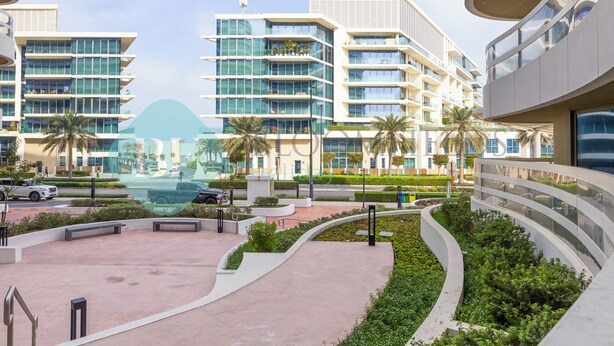 A modern hotel with multiple floors, outdoor pathways, and palm trees. - Bloomfields Superior1BR Ajwan Soul Beach (Abu Dhabi)