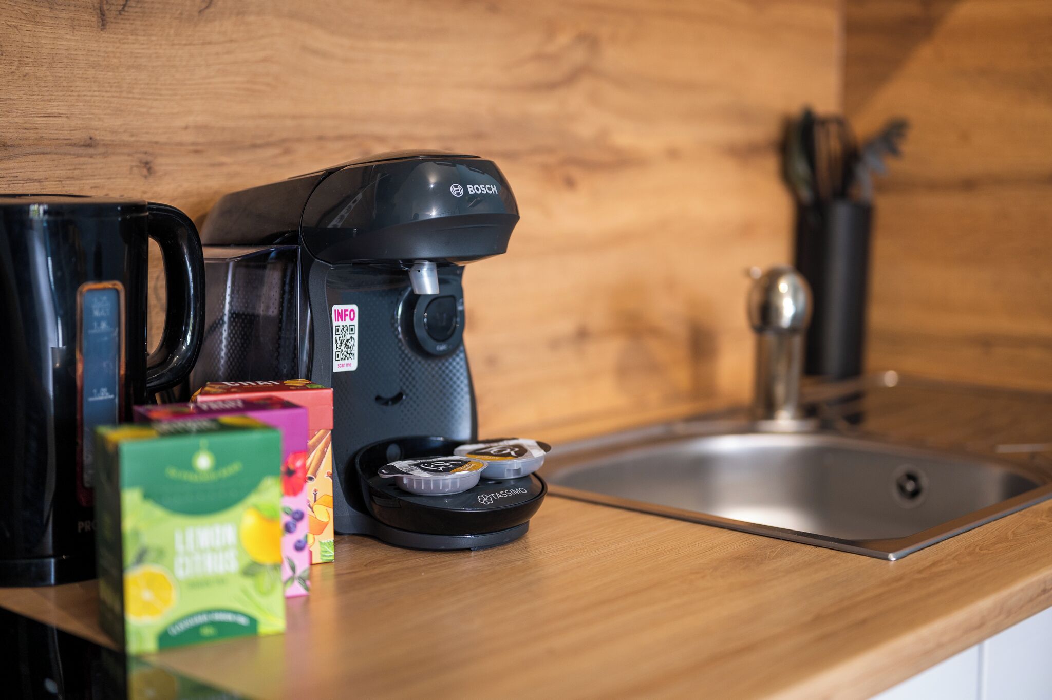 A kitchen with a Bosch coffee maker, a TASSING coffee pod holder, and a box of lemon juice.