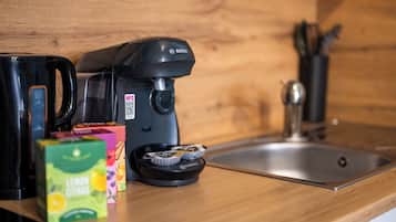 A kitchen with a Bosch coffee maker, a TASSING coffee pod holder, and a box of lemon juice.