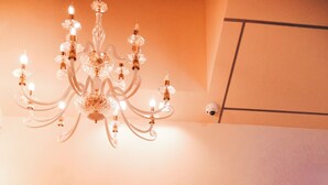 A chandelier, a sign reading "IRVS Apartments," and some greenery in the foreground. - Iris Apartments (Monopoli)