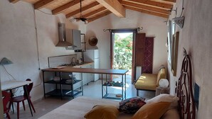 Un dormitorio con cama, escritorio y kitchenette.