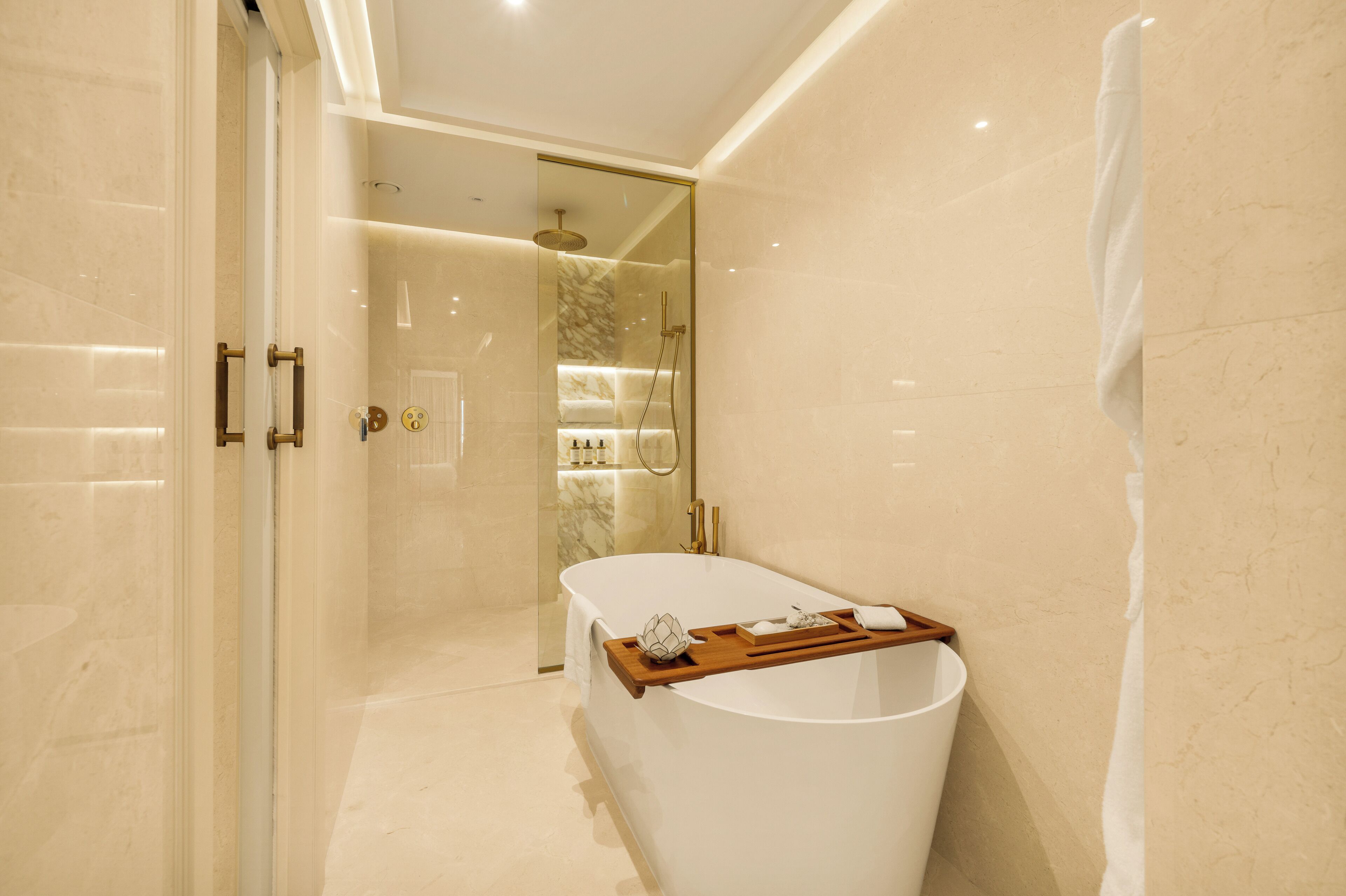 A modern bathroom with a freestanding bathtub, a glass-enclosed shower, and a vanity with a tray.