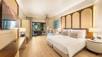 Habitación de hotel con una cama grande, un escritorio, una silla, un ventilador de techo y vistas al exterior.