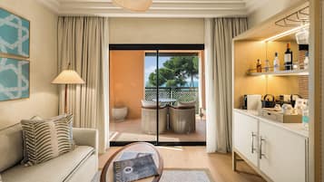 Een moderne woonkamer met een bank, een salontafel, een lamp en uitzicht op de buitenwereld door een glazen deur.