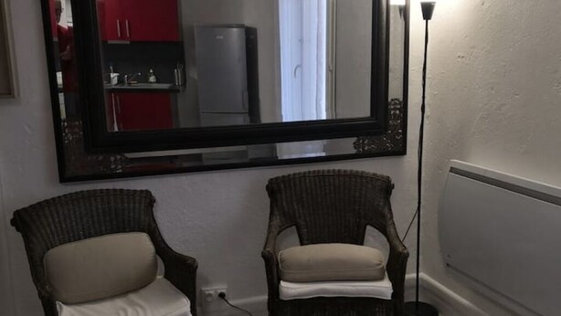A room with two wicker chairs, a table with a basket and a magazine, a large mirror, and a floor lamp. - l'Atelier USU15 downtown Grenoble (Grenoble)