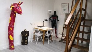 A room with a giraffe sculpture, a mannequin, a wooden table with chairs, and a wooden staircase. - l'Atelier USU15 downtown Grenoble (Grenoble)