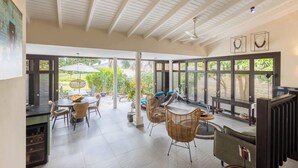 A spacious patio with a dining area, lounge chairs, and a view of the outdoors.