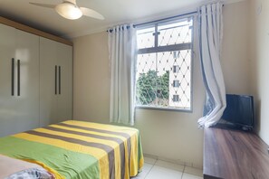 Relax in this cozy space with a comfortable bed, TV, and ceiling fan.