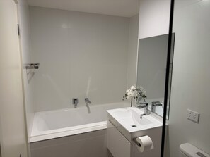 Chuveiro, toalhas de banho, sabonete, shampoo