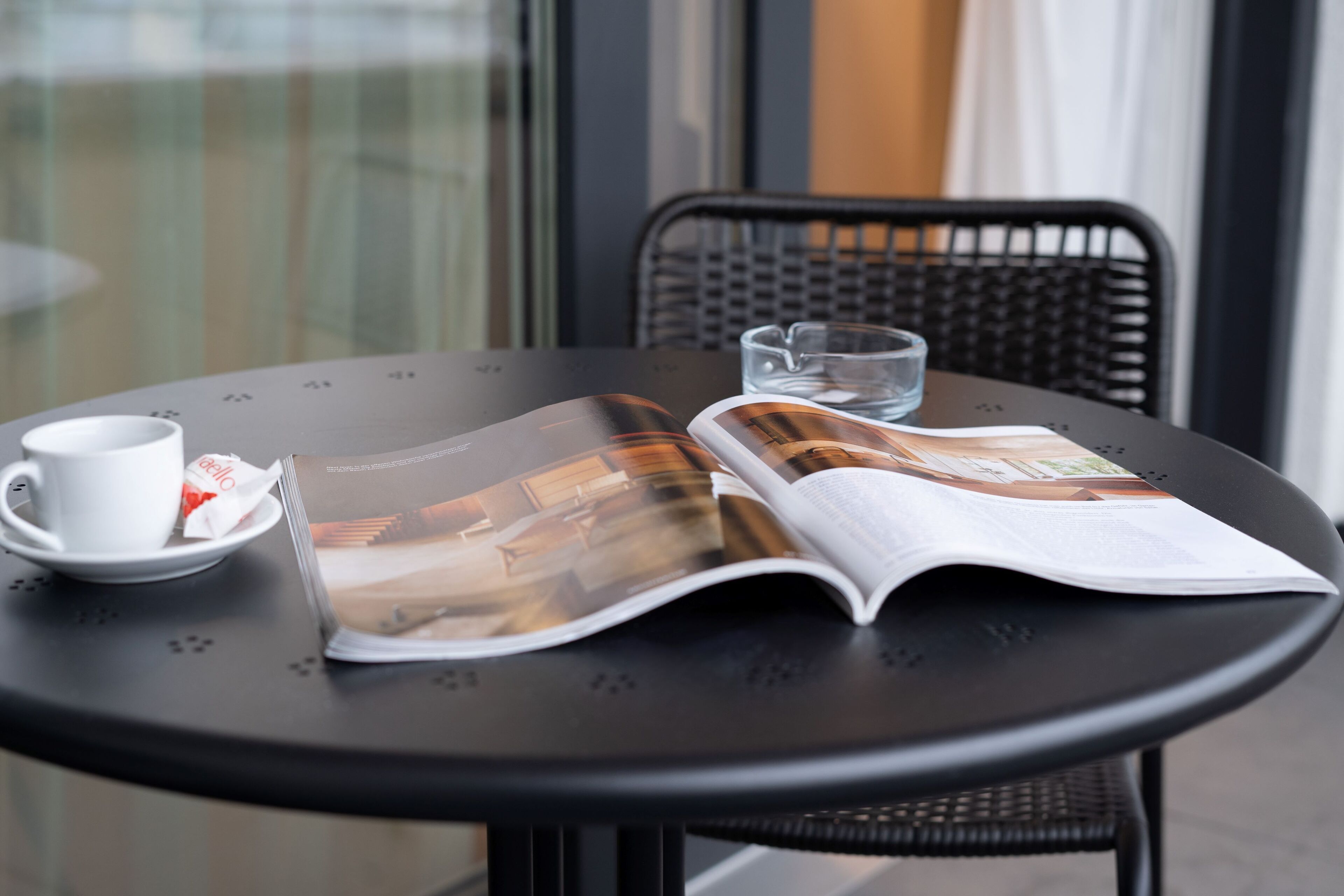 Ein Tisch mit einer Zeitschrift, einer Tasse und einem Glas Wasser.
