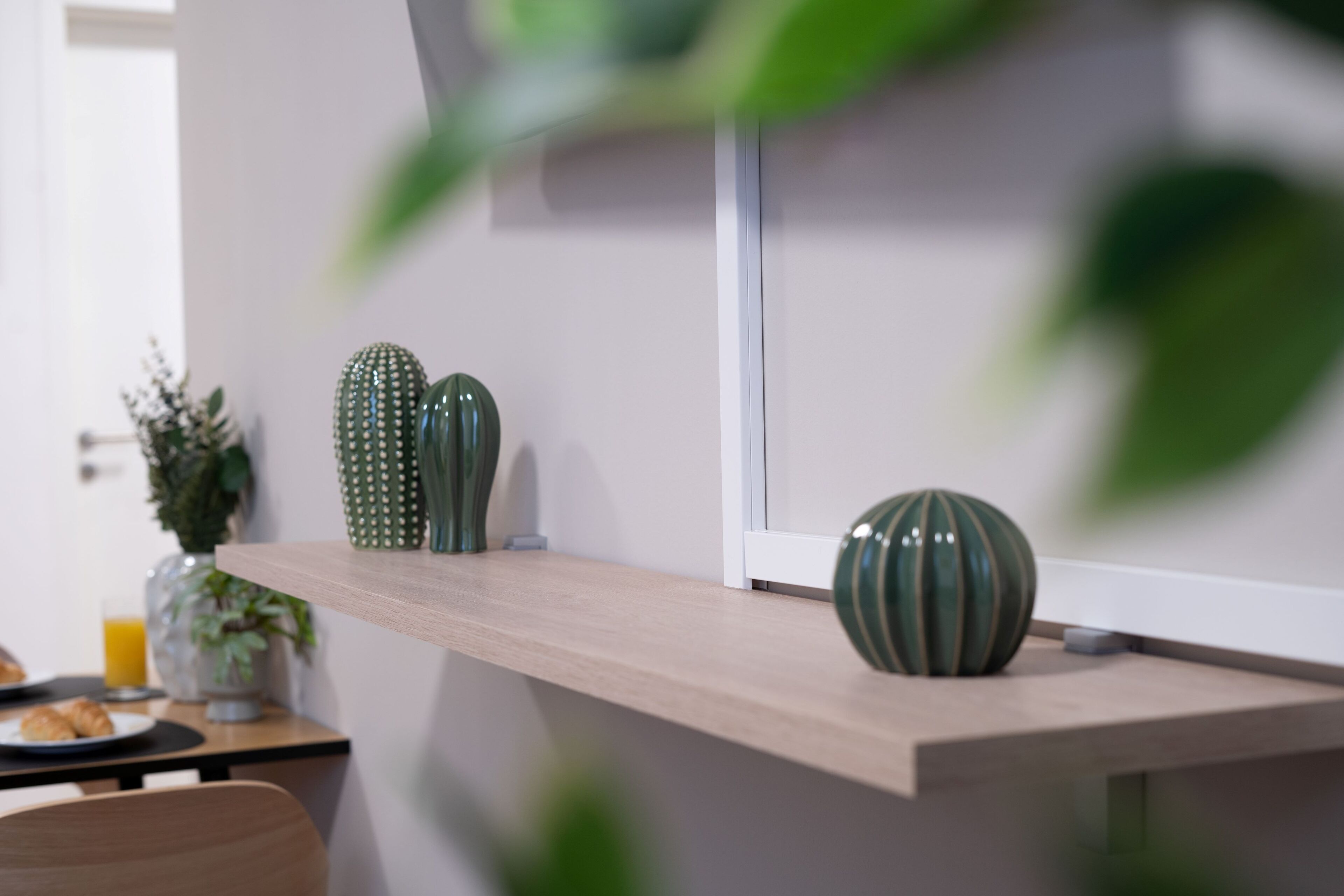 Eine Küchenzeile mit einer Holzarbeitsplatte, einer grünen Vase und einem Blumentopf.