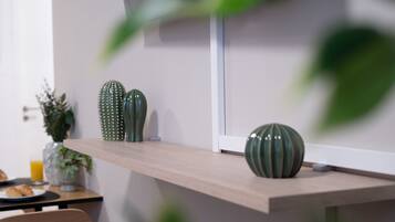 Eine Küchenzeile mit einer Holzarbeitsplatte, einer grünen Vase und einem Blumentopf.