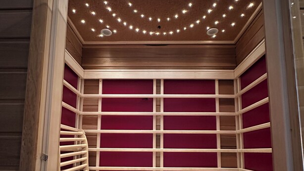 A sauna with wooden benches and a red interior.