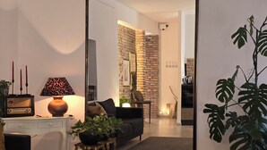 Un salon moderne avec un grand miroir, un canapé, une table basse et une lampe.