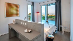 Un dormitorio moderno con una cama grande, un escritorio y vistas al exterior.