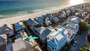 Zona residencial costera con casas de tejados a dos aguas y una playa al fondo.