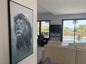 A living room with a large framed artwork, a sofa, and a television.