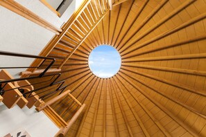 A spiral staircase with a circular skylight at the top.