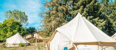Un camping con varias tiendas de campaña, incluyendo una con el rótulo "LODGING" y un cartel con el número "2".