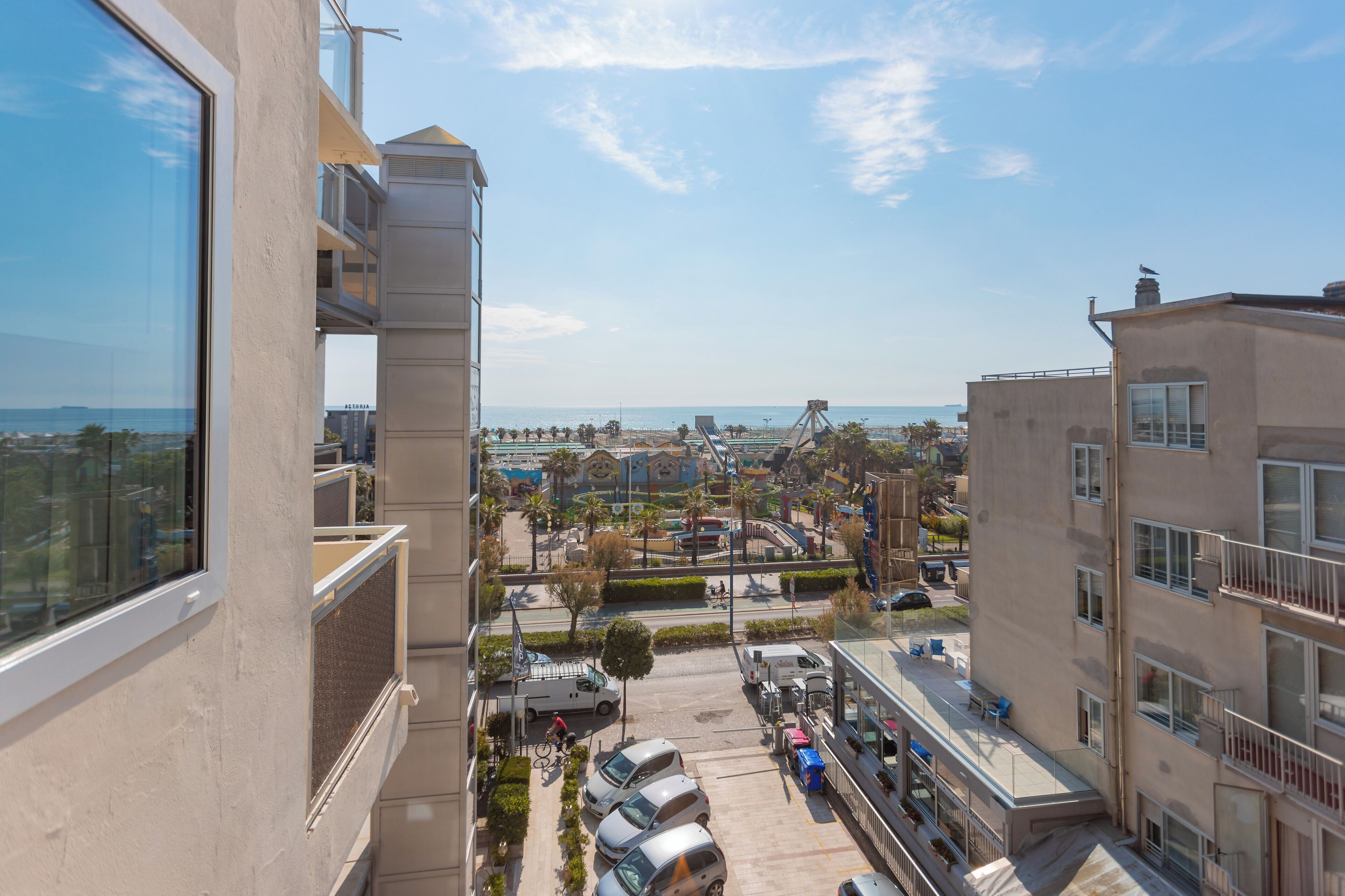 Un edificio alto con vistas a una zona costera, incluyendo una playa y un parque acuático.
