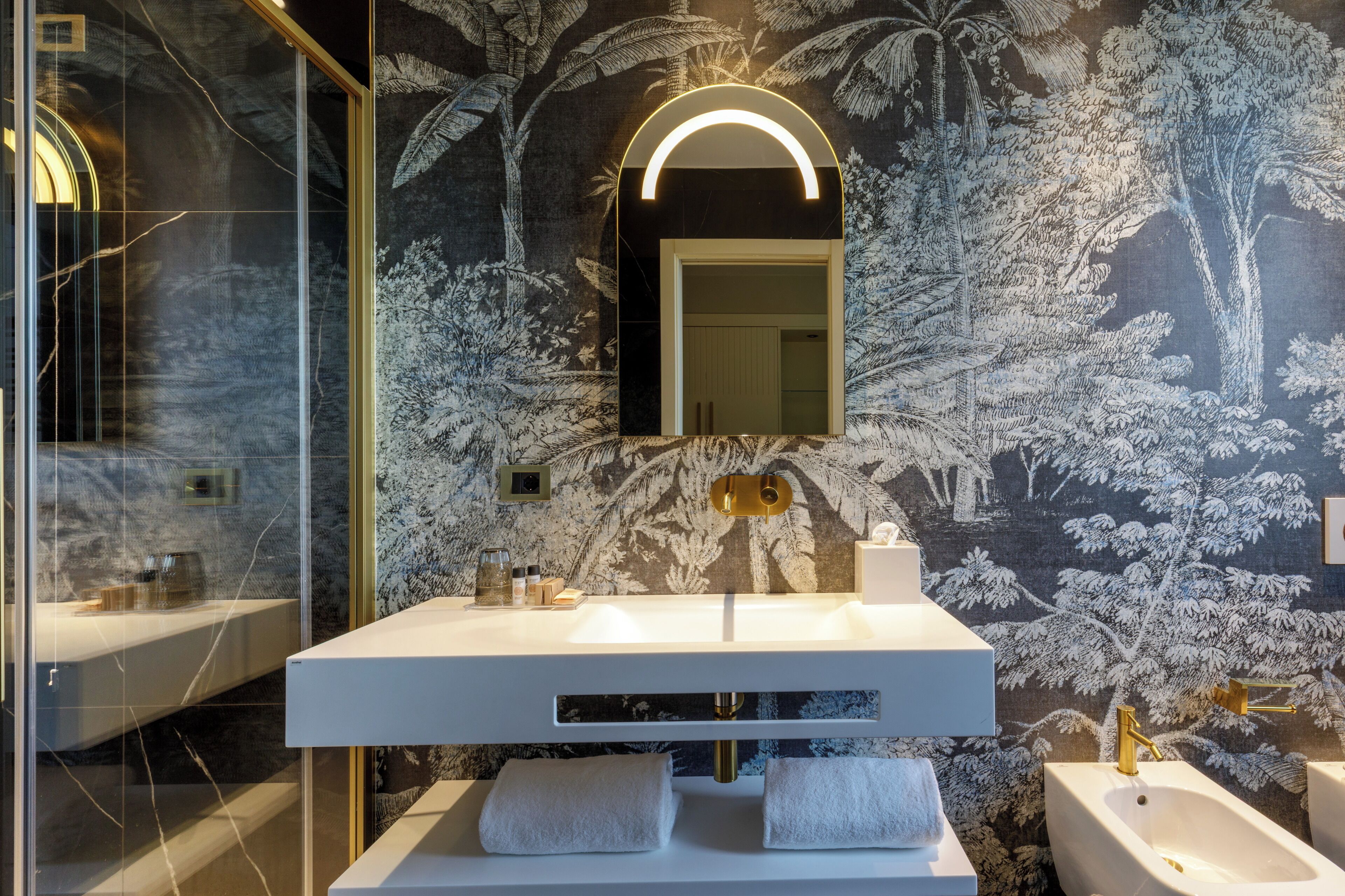 Een moderne badkamer met een grote spiegel, een witte wastafel en een bad.