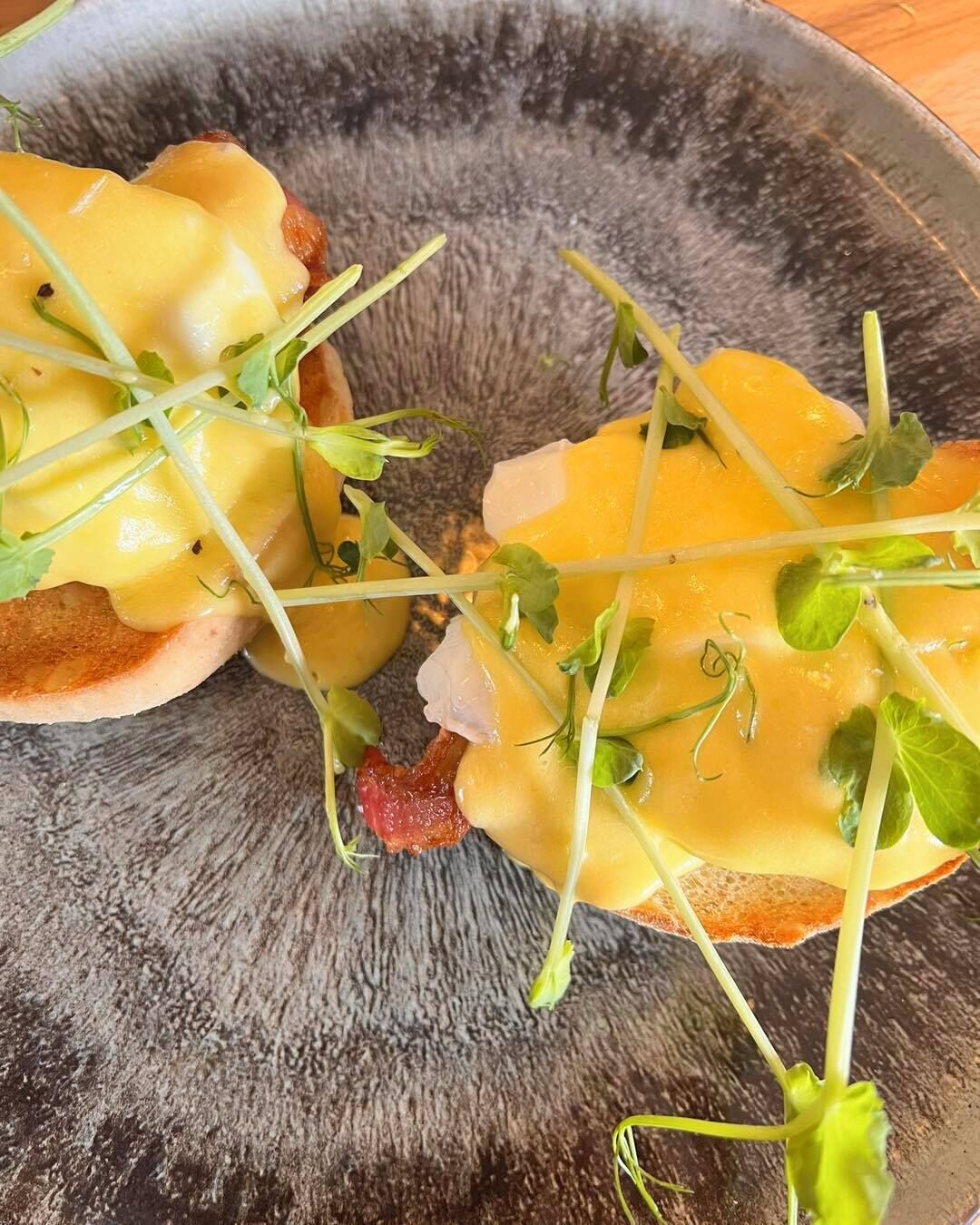 A plate with a dish consisting of bread, cheese, and greens.