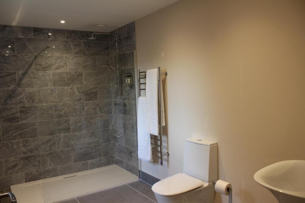 Un baño moderno con ducha, inodoro y lavamanos.