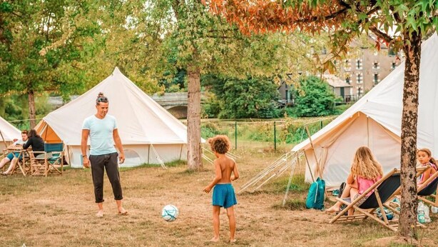 Un terrain de camping avec des tentes et des gens.