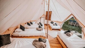 A tent with multiple beds, each with pillows and blankets. - Lodging Nature Camp Châteaux de la Loire (Cellettes)