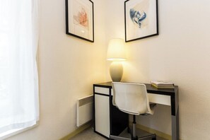 Work in comfort with a desk, chair, and ample natural light.