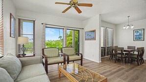 A spacious living area with a sofa, chairs, a coffee table, and a dining set. - Aston Poipu Kai Kauai 114 | Garden View Retreat – Pool & Hot Tub (Koloa)