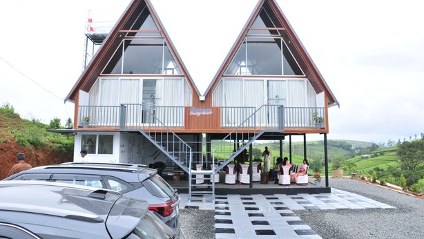 Il s'agit d'un bâtiment à deux étages, doté d'une façade en bois et de grandes fenêtres. Un espace extérieur abrité, avec des tables et des chaises, est aménagé pour accueillir les clients.