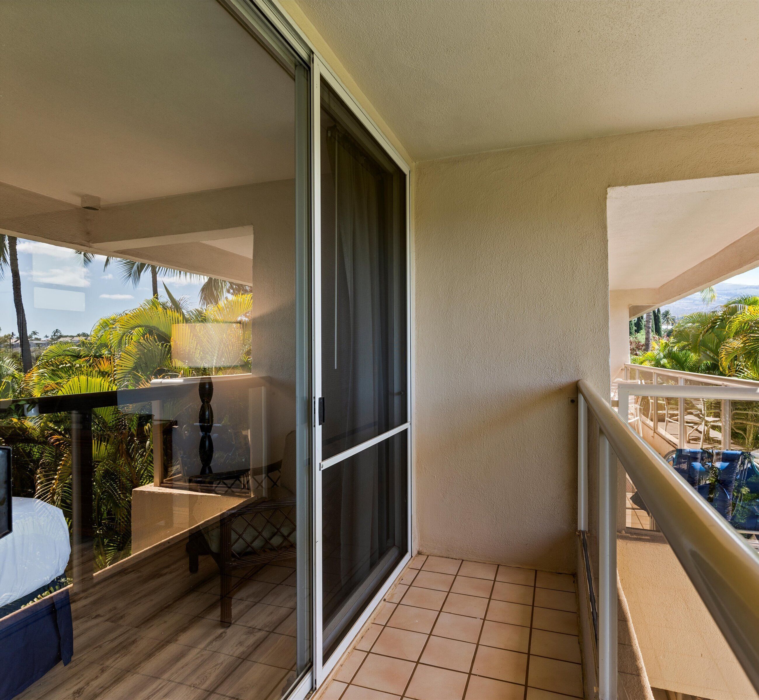 A balcony with a sliding glass door, a small table, and chairs.