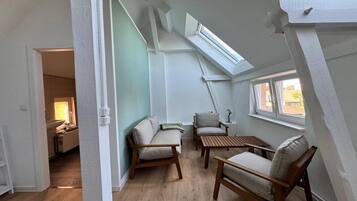 A room with a sloped ceiling, a skylight, and a view of the outside.