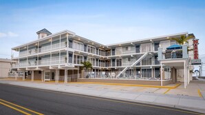 A multi-story hotel with balconies, a visible staircase, and a sign reading "Harbor Light".
