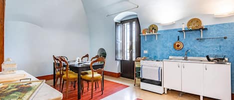 Una cocina con comedor, que incluye estufa, pileta y sillas.