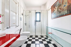 A modern bathroom with a checkered floor, a glass shower enclosure, and a red and white sink. - Nella Apartment With Pool (Sannicandro di Bari)