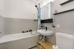 A modern bathroom with a bathtub, a sink, and a toilet. - Residenza Tasso Sul Lago in Castagnola (Lugano)