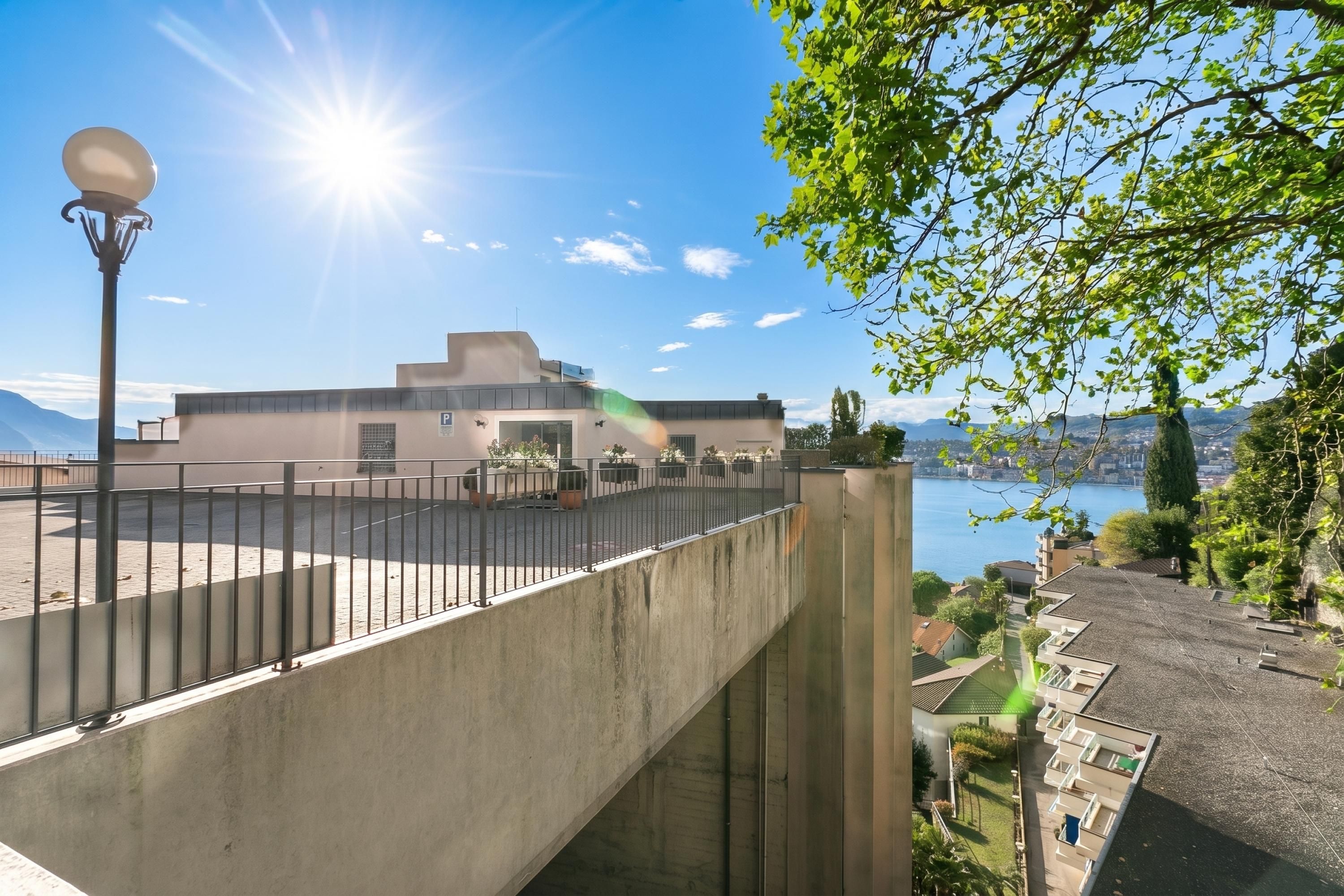 Ein modernes Gebäude mit Flachdach, Betontreppe und Blick auf ein Gewässer.
